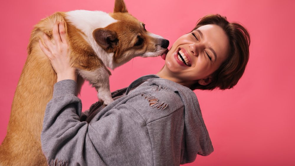 Una ragazza felice gioca con il proprio cane.